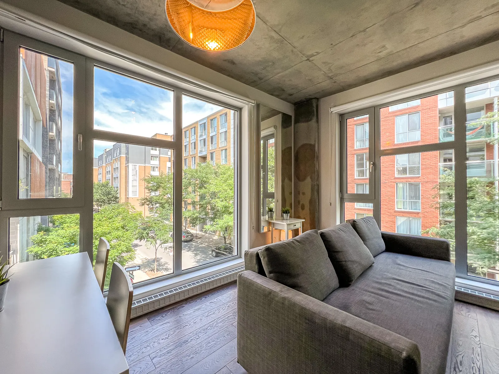 Corner living room with floor-to-ceiling windows and a grey sofa