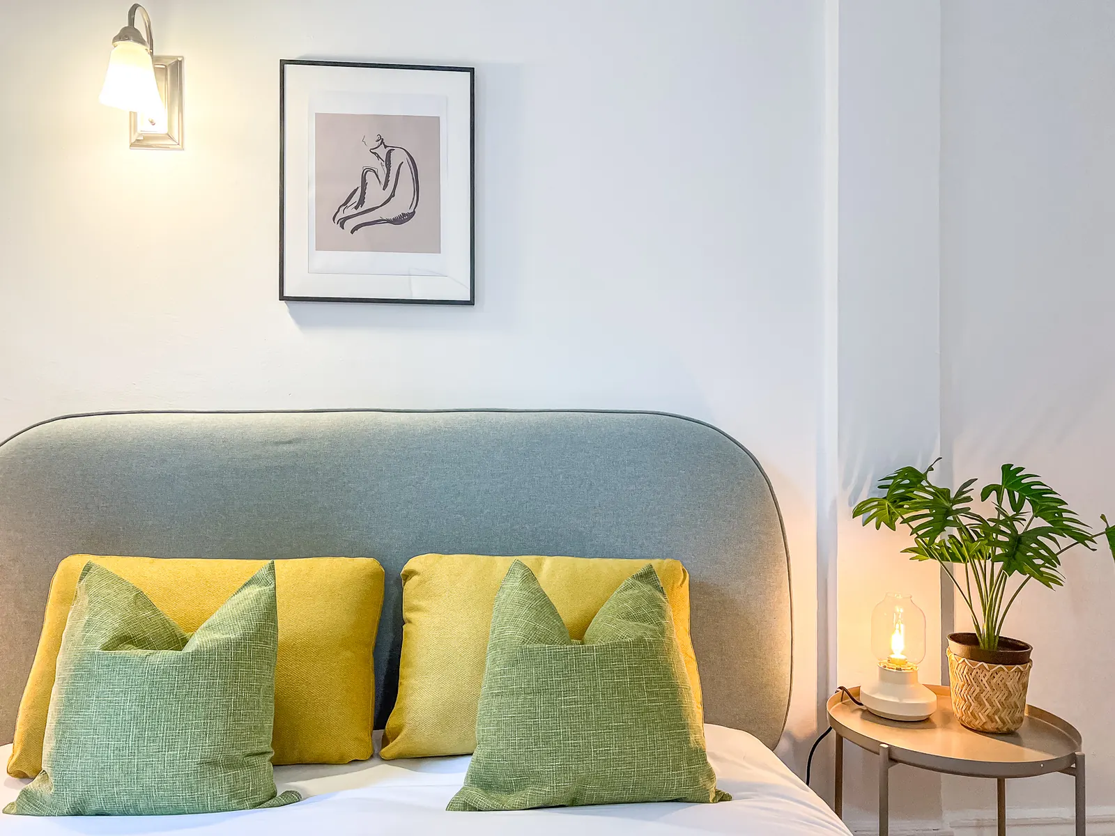 Bedroom with upholstered headboard and yellow and green pillows