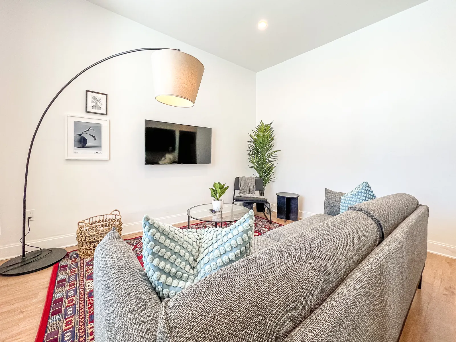 Living room with arc floor lamp, sectional sofa and wall-mounted TV
