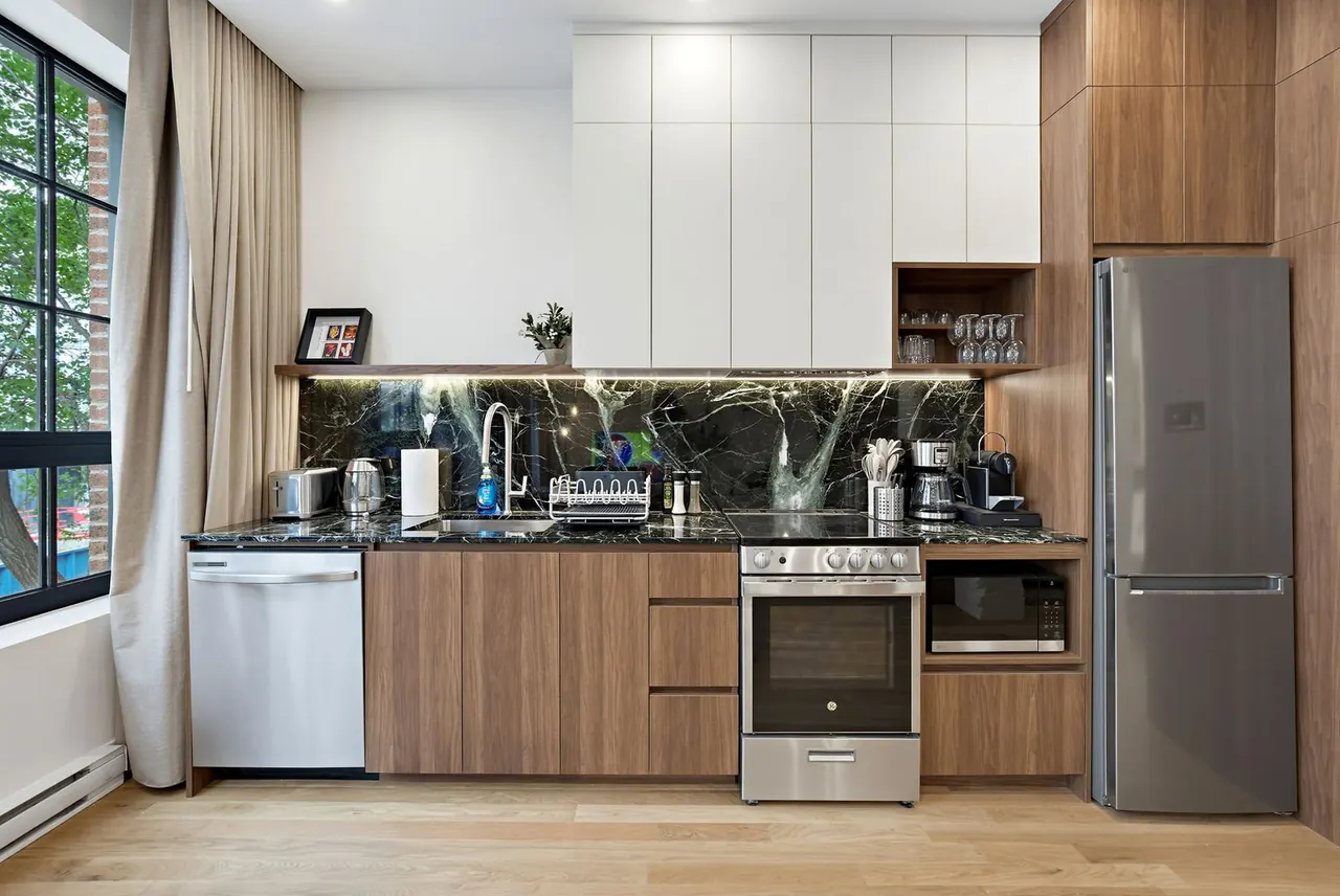 Modern kitchen with dark stone backsplash and stainless appliances